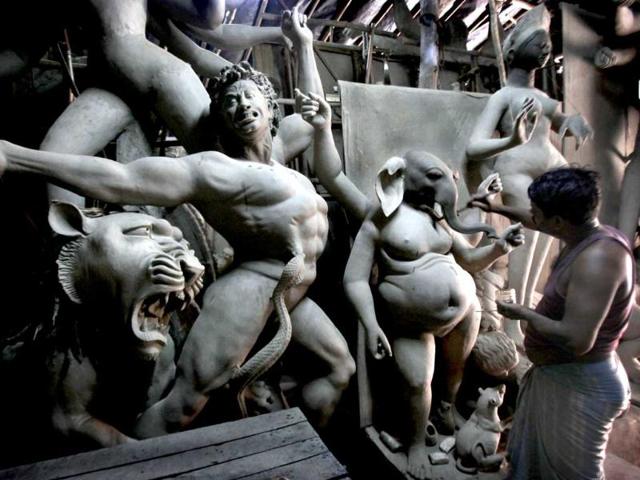 An artisan prepares an idol of elephant-headed God Ganesh, ahead of the Durga Puja festival in New Delhi, India.