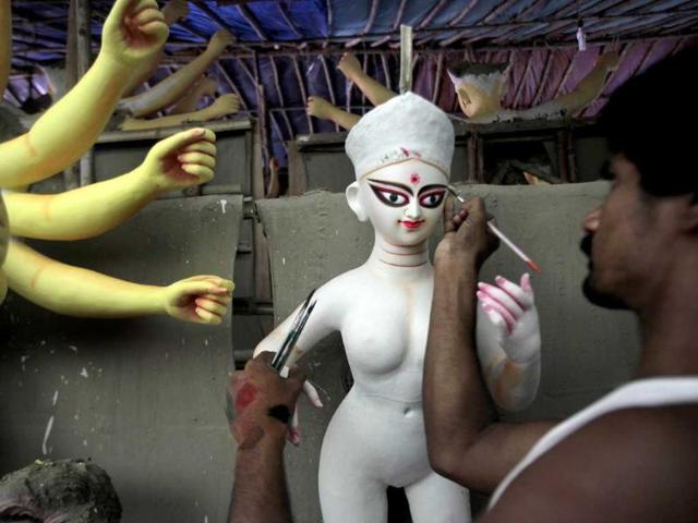 An artisan paints the eye of an idol of Goddess Durga, ahead of the Durga Puja festival in New Delhi, India.