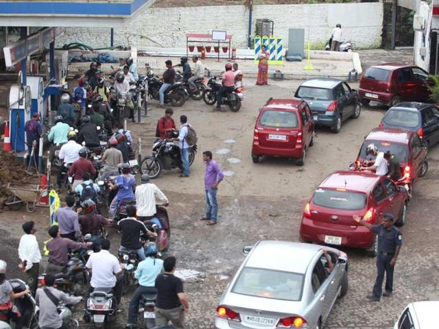 Car and bike owners get their fuel tank filled with petrol from a petrol-pump at Borivli in Mumbai before the proposed price hike from midnight.