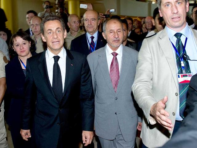 French President Nicolas Sarkozy and President of the National Transitional Council Mustafa Abdul Jalil walk through the lobby of the Corinthia hotel in central Tripoli.