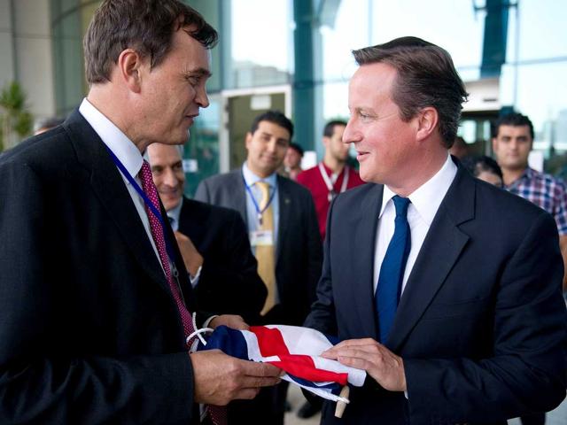 Britain's Special Representative to Libya Dominic Asquith receives a Union Flag from British Prime Minister David Cameron