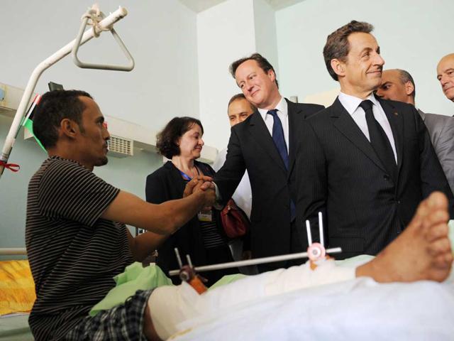 British Prime Minister David Cameron (C) and French President Nicolas Sarkozy (R) meet patients at the Tripoli Medical Centre in Tripoli, Libya.