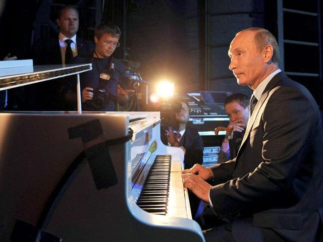Russia's Prime Minister Vladimir Putin plays the piano while visiting the Theater of Nations in Moscow. 