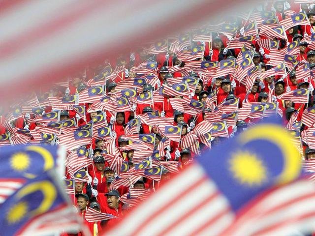 Malaysians wave the national flags during the double celebrations of Malaysia Day and Independence Day in Kuala Lumpur. 