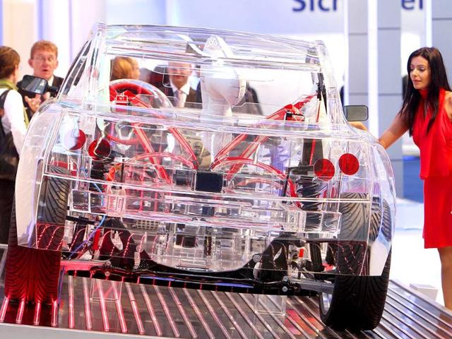 A model stands next to a transparent car showing security components at the 64th Frankfurt Auto Show in Frankfurt, Germany. 