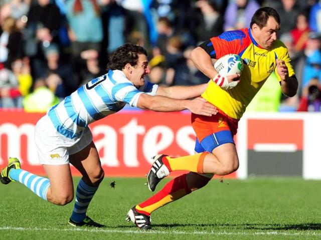 Romania's No8 Daniel Carpo (R) runs with the ball ahead of Argentina's fly-half Santiago Fernandez during the 2011 Rugby World Cup pool B match Argentina vs Romania at the Rugby Park stadium in Invercargill.
