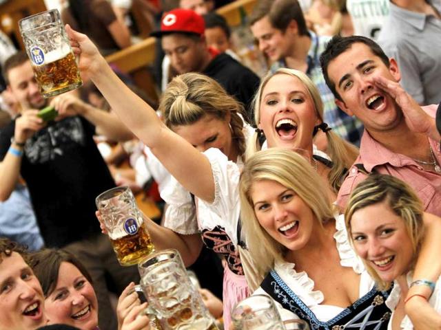 Young people lift up their beer steins after the official opening of the famous Bavarian Oktoberfest festival in Munich, southern Germany.