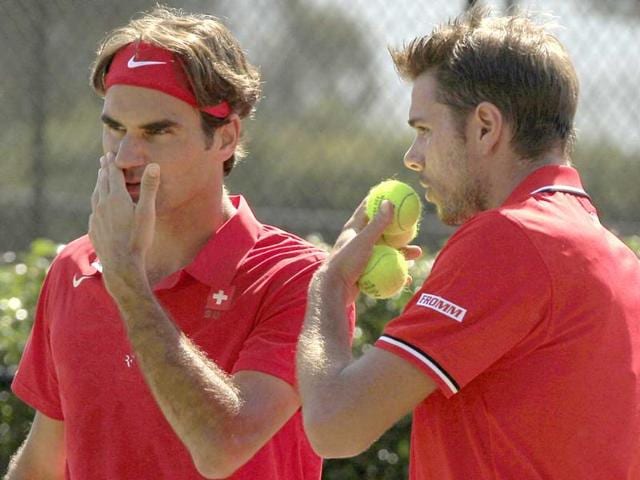 Switzerland's Roger Federer (L) and teammate Stanislas Wawrinka discuss tactics in a play against Australia's Lleyton Hewitt and Chris Guccinone during their doubles tennis match in a Davis Cup world group playoff in Sydney.