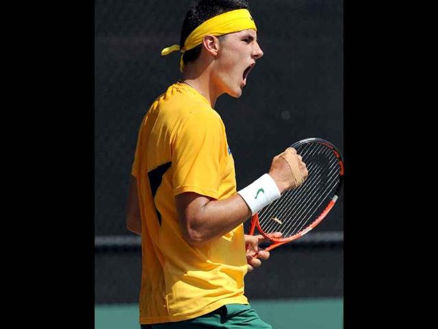 Bernard Tomic of Australia celebrates winning the third set against Roger Federer of Switzerland during the fourth match of the Davis Cup world group play-off tie in Sydney.
