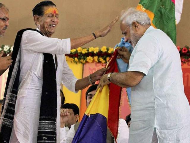 A priest presents a flag to Gujarat's chief minister Narendra Modi during the second day of his fast in Ahmedabad.