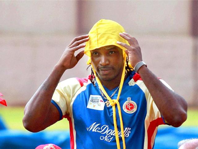 Royal Challengers Bangalore player Chris Gayle covers his head during a practice session for Champions league 2011 at National Cricket Academy ground in Bangalore.