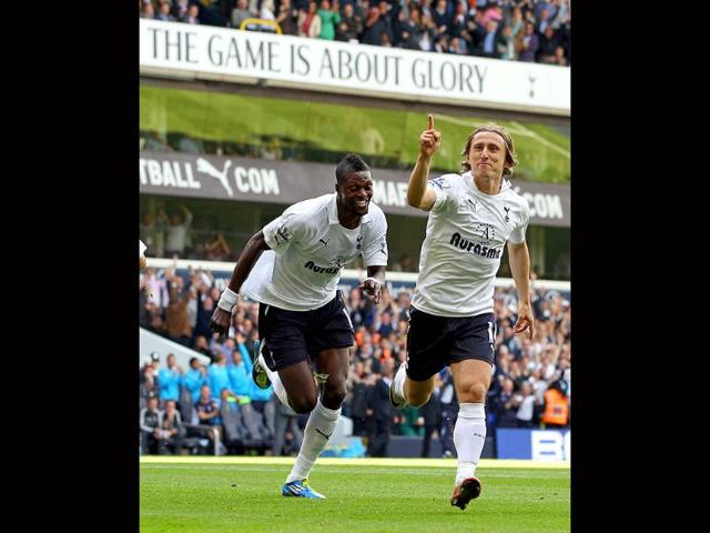 Tottenham Hotspur's midfielder Luka Modric (R) celebrates scoring the opening goal with teammate Emmanuel Adebayor (L) during of the English Premier League football match against Liverpool ain north London, England.