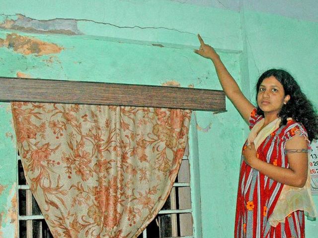 A lady shows crack in her wall after an earthquake occurred in Kolkata.