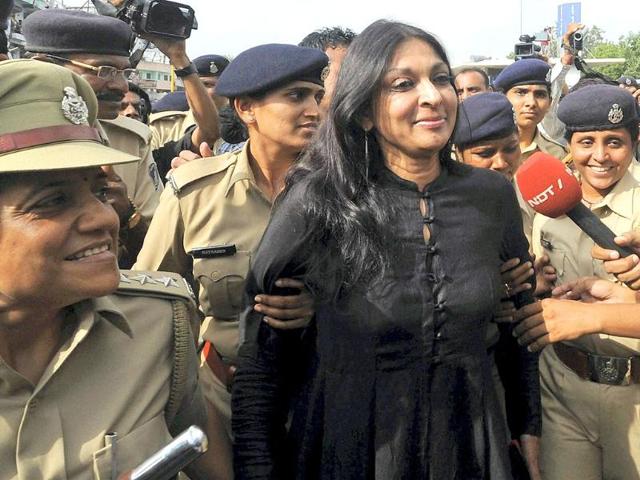 Mallika Sarabhai walks with police women after being detained along with some Gujarat riots victims in Ahmedabad.