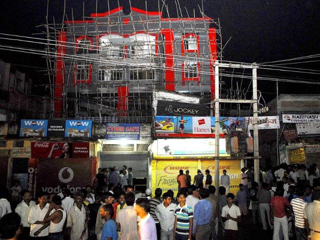 People who rushed out of buildings following tremors stand on the street in Patna.