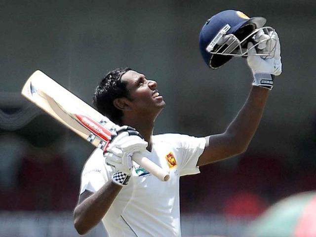 Sri Lankan batsman Angelo Mathews raises his bat after scoring a century (100 runs) during the fourth day of the third and final Test match between Australia and Sri Lanka at The Sinhalese Sports Club (SSC) Ground in Colombo.