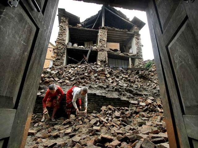 Nepalese women remove bricks of the damaged house to make way for pedestrians after an earthquake of magnitude 6.9 shook northeastern India and Nepal.