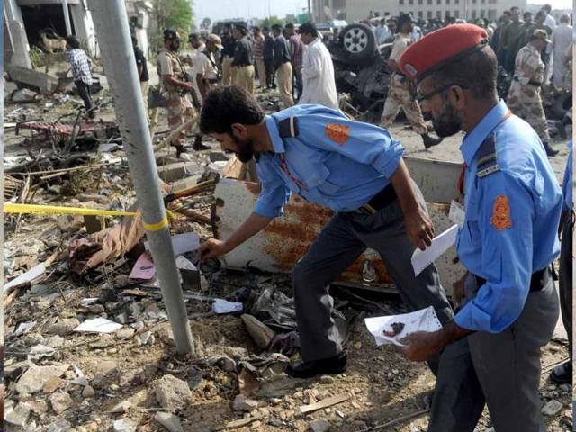 Pakistani investigators inspect the site of a car bomb blast in Karachi.