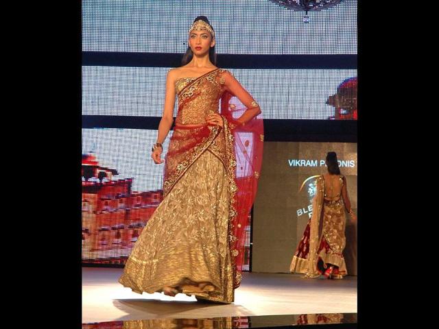 A model shimmers in a golden lehenga by designer Vikram Phadnis.