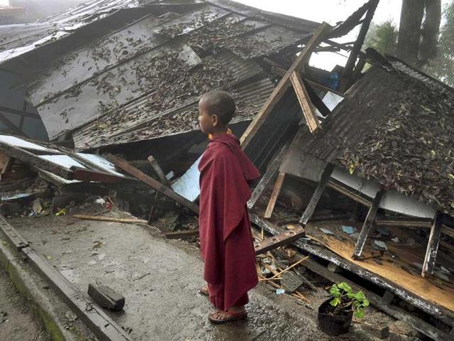 A young Buddhist monk looks on at a monastery damaged by Sunday's earthquake in Gangtok.