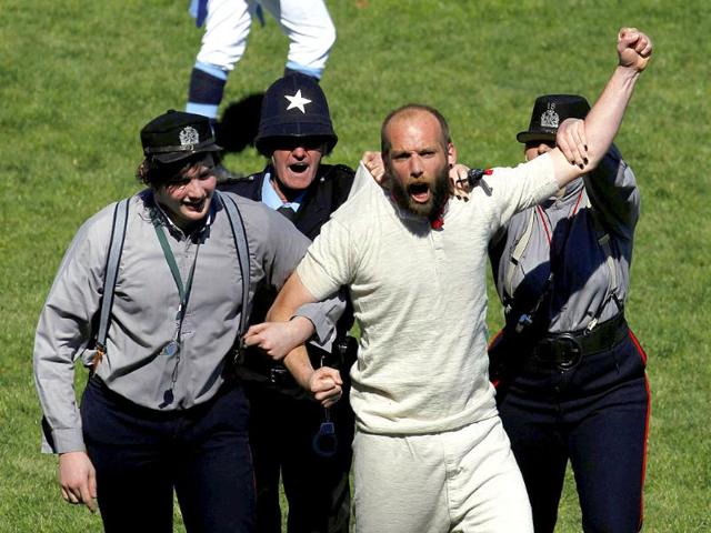 Men dressed as policemen "arrest" a streaker during the re-enactment of the first rugby match ever played in New Zealand.
