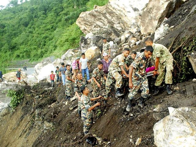 Nepalese soldiers carry an injured civilian over an area hit in a landslide following a 6.8 magnitude earthquake, near Dharan in the Dhankuta district of eastern Nepal.