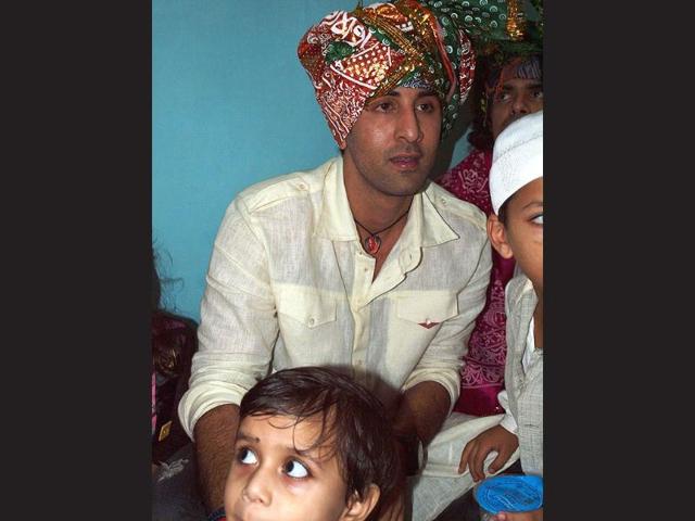 Ranbir Kapoor in a white kurta and red and green turban.