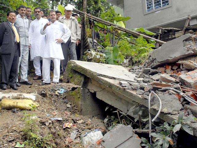 Rahul Gandhi (4L) and Sikkim chief minister Pawan Chamling (L) stand with officials as they inspect damaged homes in Lumsey on the outskirts of Gangtok.