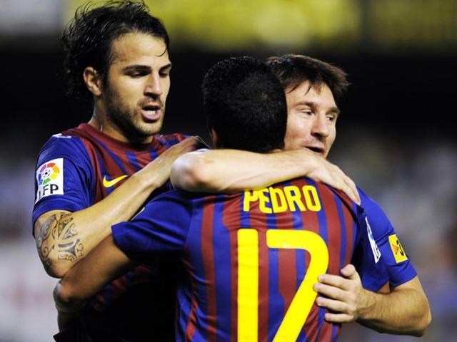 Barcelona's forward Pedro Rodriguez (C) celebrates with teammates Barcelona's forward Cesc Fabregas (L) and Barcelona's Argentinian forward Lionel Messi after scoring a goal against Valencia during their Spanish League football match in Valencia.