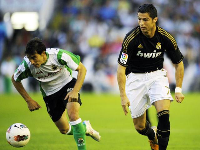 Racing Santander's defender Francisco Jesus Perez (L) vies with Real Madrid's Portuguese forward Cristiano Ronaldo during the Spanish league football match Racing vs Real Madrid at El Sardinero Stadium in Santander.