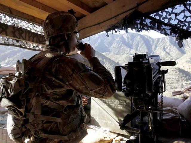 A US soldier from Task Force "No Fear" Alpha Company, 2-27 Infantry "The Wolfhounds", drinks soda as he looks out from his post in a bunker overlooking a village in Combat Outpost Pirtle King in Ghaziabad district, Kunar province, eastern Afghanistan.