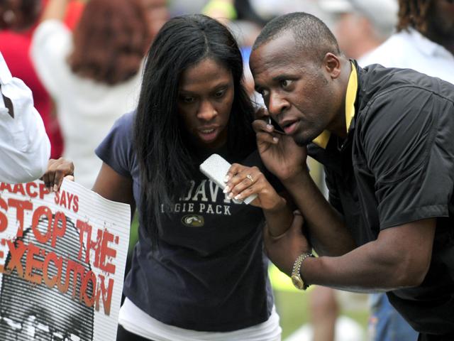 Anti-death penalty protesters listen to news about the delay of the execution by the U.S. Supreme Court for Georgia death row inmate Troy Davis in Jackson, on Wednesday, Sept. 21, 2011.