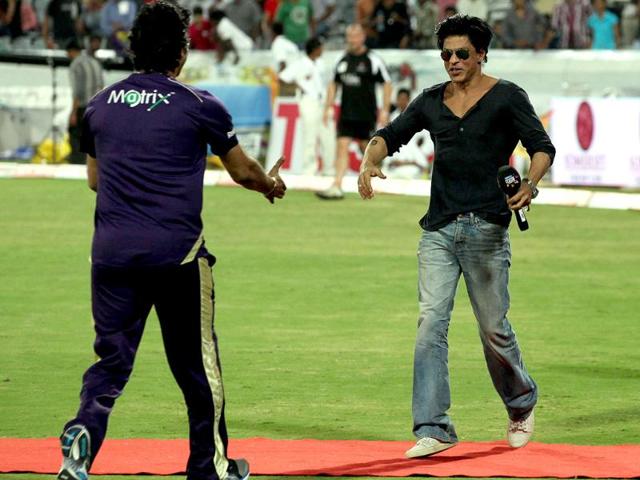 SRK greets team coach Wasim Akram.