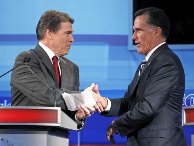 Texas governor Rick Perry (L) shakes hands with former Massachusetts governor Mitt Romney after the Republican Party of Florida presidential candidates debate in Orlando.