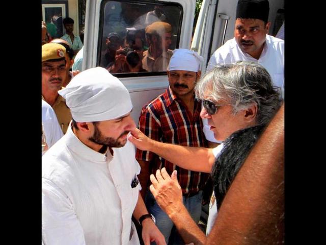 Bollywood actor and son of Mansoor Ali Khan Pataudi, Saif Ali Khan, is seen speaking to an unidentified man during his father's funeral procession in New Delhi.