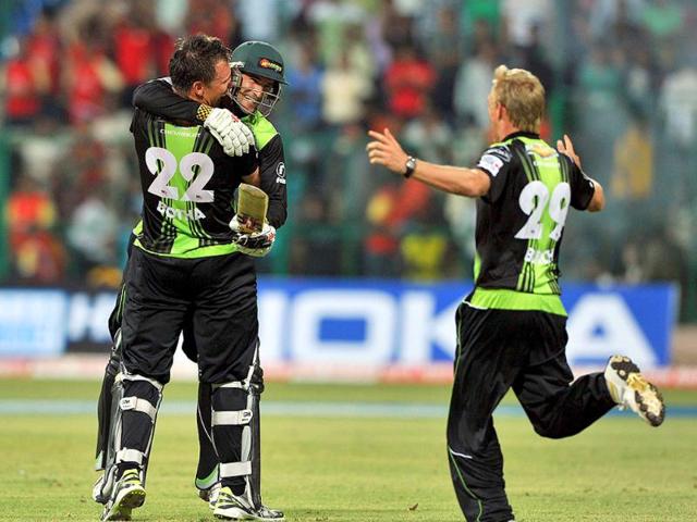 Warriors' batsman Wayne Parnell (C) hugs teammate Johan Botha while Andrew Birch (R) comes running to celebrate their victory over RCB during the Champions League Twenty20 League group B match.