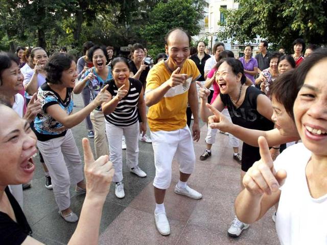 Yoga master Le Anh Son (C) and members of the Laughter Yoga club practise laughing during morning exercise at a public park in Hanoi.