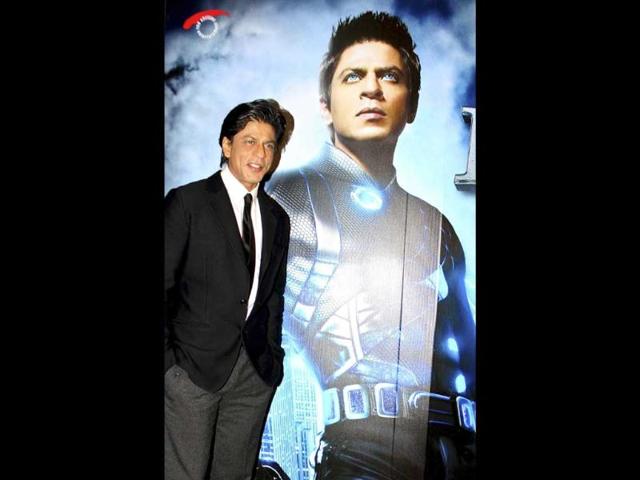 SRK poses in front of RA.One's poster.
