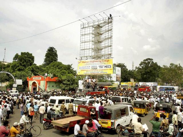 Telangana supporter A Srinivas threatens to commit suicide by jumping off the top of a hoarding in Hyderabad, Andhra Pradesh, during a protest.