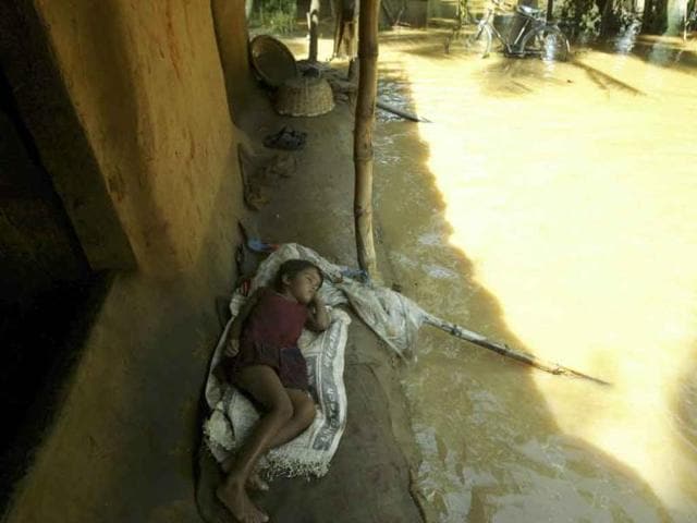 A girl sleeps in her mud hut surrounded by flood waters at Pahanga village in Orissa's Jajpur district. Monsoon rains have collapsed mud huts and flooded wide swaths of north and east India in recent days.
