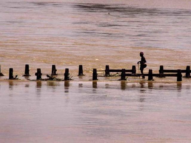 A villager stands on top of a bridge at Rasulpur village in Orissa's Jajpur. According to officials, the floods have affected more than 2.1 million people in 3,128 villages.