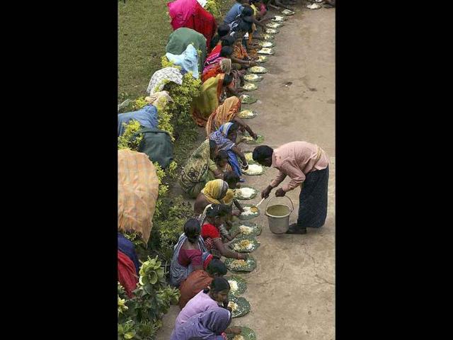 Villagers from flood affected villages eat food at Rasulpur village in Orissa's Jajpur district.