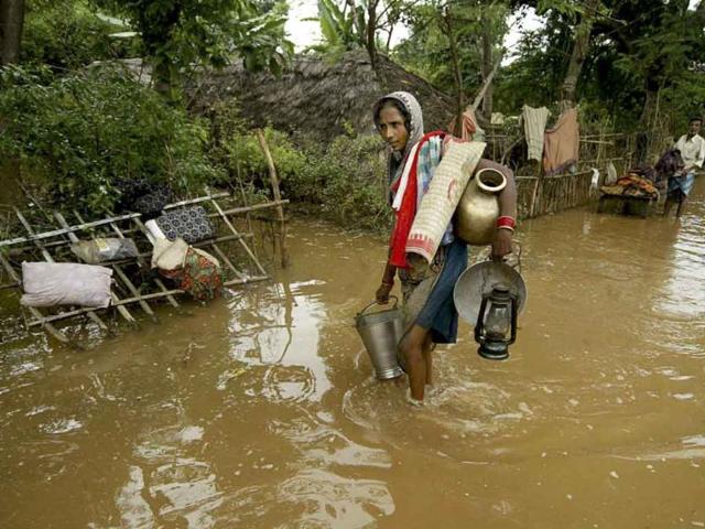 A woman returns to her village through flood waters at Rasulpur village in Orissa's Jajpur district. The monsoon season, which runs from June through September, brings rains that are vital to agriculture but also cause floods and landslides.