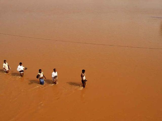 Villagers carrying relief materials walk through flood waters at Rasulpur village in Orissa's Jajpur district. The floods have killed 59 people, in what experts describe as the worst Orissa has faced in three decades, more destructive than those in 1982 and 2008.