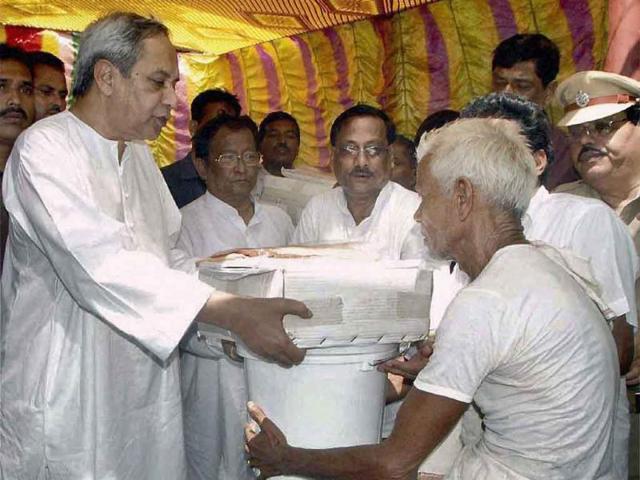 Orissa chief minister Naveen Patnaik distributes relief materials to a flood hit villager at Bilipada village of Banki in Cuttack.