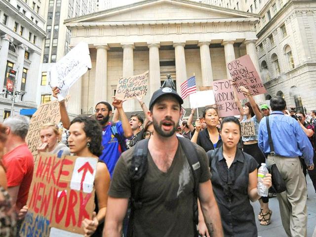 Protestors march past Federal Hall on Wall Street.