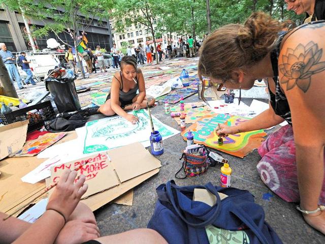 Cardboard signs are made to be added to the dozens already covering the pavement of Zuccotti Park.