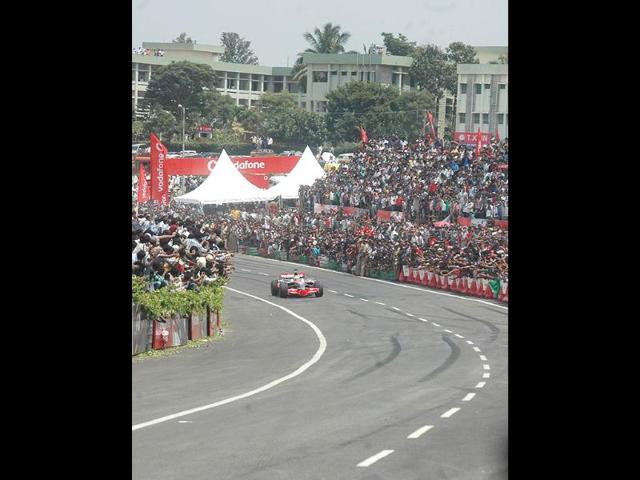 McLaren Mercedes driver Lewis Hamilton on the award winning MP4-23 car during the Formula One car run at Nice road in Bangalore.