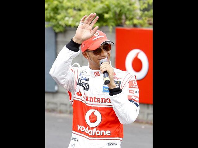 McLaren F1 driver Lewis Hamilton of Britain acknowledges the crowd after performing at the Bangalore-Mysore highway during a promotional event ahead of the India Formula One Grand Prix, on the outskirts of Bangalore.