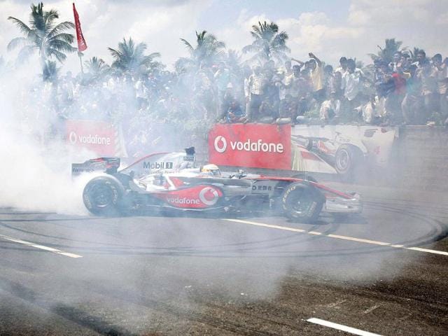 McLaren driver Lewis Hamilton of Britain performs on the Bangalore-Mysore highway during a promotional event ahead of the India Formula One Grand Prix, on the outskirts of Bangalore.